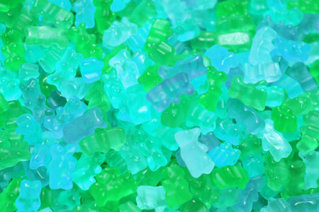 Colorful texture using as background. A lot of sweets. Background 3d rendering illustration. Orange and black multiple jelly candies in powdered sugar. Confectionery wallpaper concept. Copy space. Shallow focus. High quality photoの写真素材