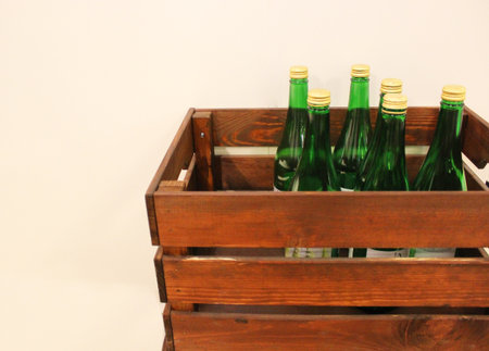 Wine bottles in a box close up. Box with bottles of drink in a wooden box on a white wooden background. With copy space. Wine background. The concept of the holiday, feast, celebration. drinks shopの写真素材