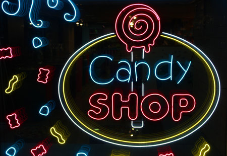 neon letters Candy shop with neon lighting on the glass, the concept of a cafe and coffee, and sweets Glowing neon lettering and stylized,. Vintage image in dark tones.の写真素材