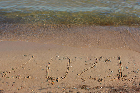 New Year 2022. Message written on the background of a sandy beach. hello concept for the upcoming new year 2022.の写真素材
