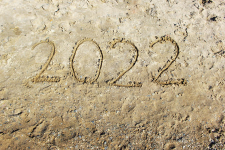 New Year 2022. Message written on the background of a sandy beach.の写真素材