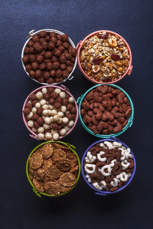 Dry breakfast, granola, muesli on a black background vertically top view copyspace flat lay