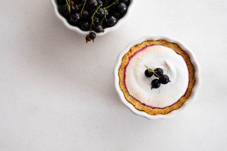 Homemade pie with summer berries and coffee closeup in a baking dish on a white table.Top view from...