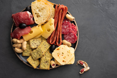 Meat and cheese plate.Traditional italian antipasto, cutting board with salami, cold smoked meat, prosciutto, ham, cheeses, olives, capers. Cheese and meat appetizer. Top viewの写真素材