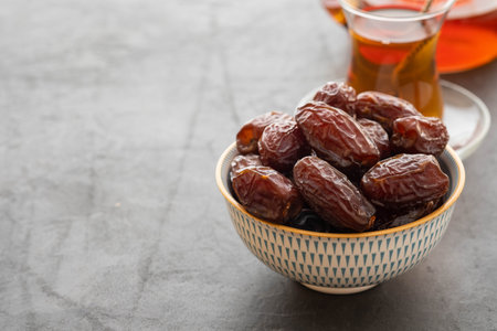 Fresh Medjool Dates in a bowl. Ramadan kareem. Black background. Top view. Copy space.の写真素材