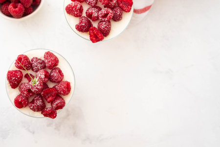 Raspberry dessert, raspberry tiramisu, cheesecake, trifle, mousse in a glass on a wooden...