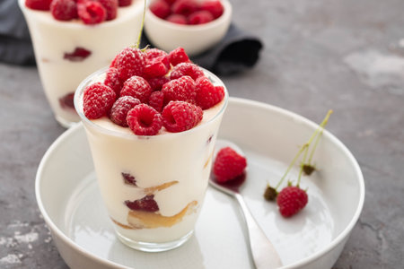 Tiramisu with raspberry in glasses on grey background. Italian dessert. Copy space.の写真素材