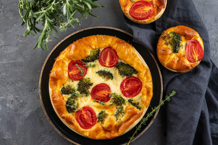 Vegetable pie with broccoli, tomatoes on the table close-up. Copy space.の写真素材