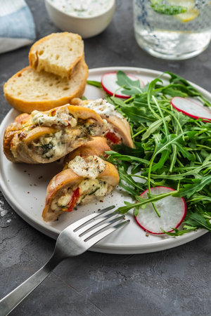 Roasted chicken breasts stuffed with mushrooms, green onion, pepper and garnished fresh salad and rocket salad.の写真素材