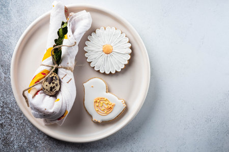 Table setting for the holiday of Easter. The photo shows white dishes, serving mat, Easter egg in a...