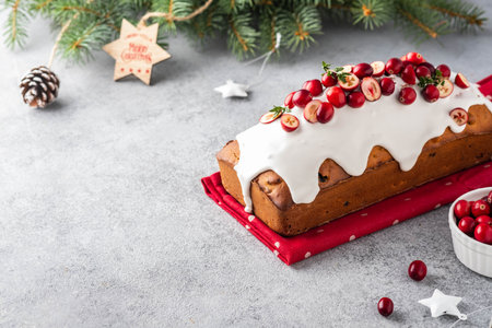 Christmas cake with cranberries and Christmas decorations on a gray background. Copy space.の写真素材