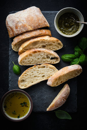 Mediterranean snacks set. Olives, oil, herbs and sliced ciabatta bread. Top view.
