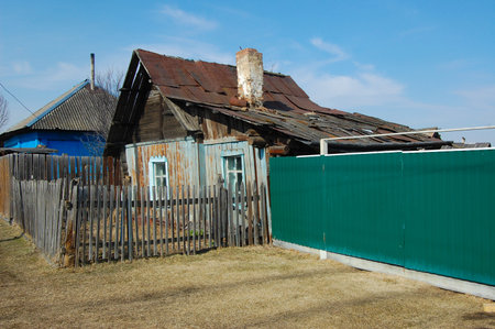 an old village house with a green fenceの写真素材