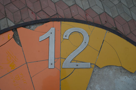 the number 12 on the background of a broken yellow-orange background and asphaltの写真素材