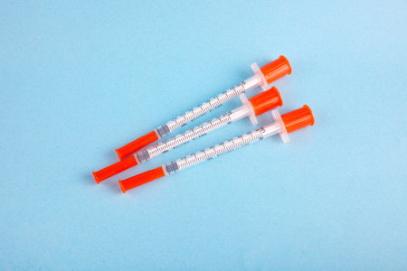 Insulin syringes on a blue background. World Diabetes Day, November 14. Diabetes concept.