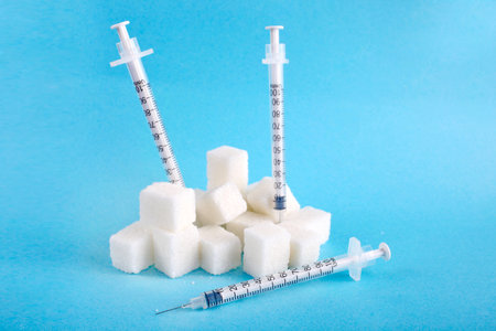 Three insulin syringes and lump sugar on a blue background. World Diabetes Day, November 14. Diabetes concept.の写真素材