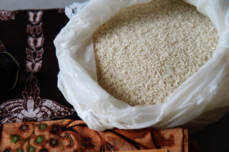 white bag with rice in the bazaar against the background of painted fabricsの写真素材