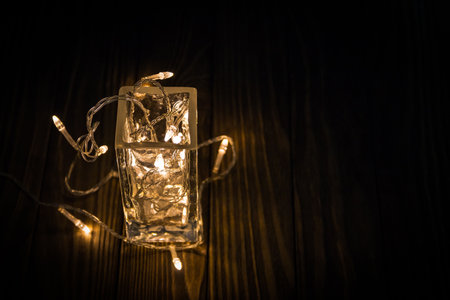 Garland in a glass. at night time on wooden backgroundの写真素材