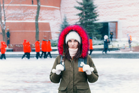Winter portrait of a young woman against the backdrop of people in red jackets.の写真素材