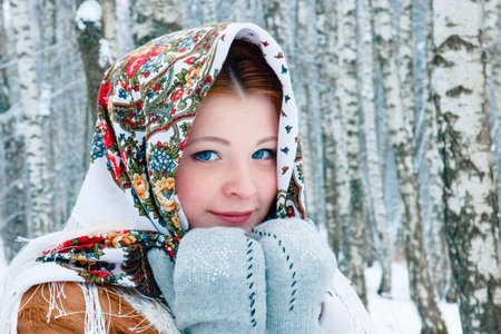 girl - Slavic appearance smiles. wrapped in a scarf in winter.の写真素材