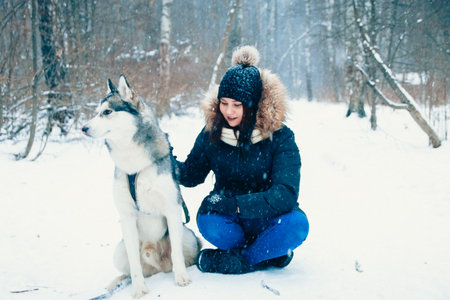 girl and a dog in the winter forest.の写真素材