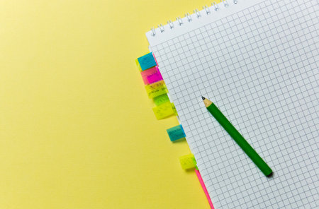 notepad with bookmarks, pencil for recording on yellow background. Office themeの写真素材