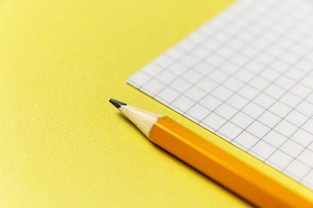 notebook and a green pencil on blue background. Office themeの写真素材