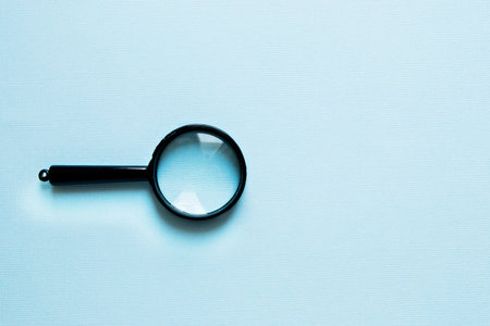 Black little Magnifier on a blue background.の写真素材