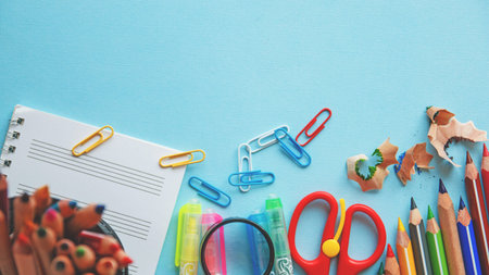 Different school or office supplies on a blue background. Education or business concept. Empty place...
