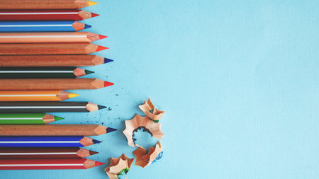 colored pencils and pencil shavings on blue background.の写真素材