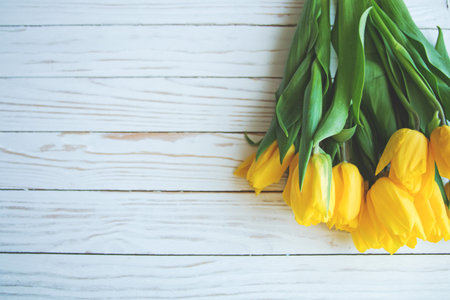 bouquet of yellow tulips on a white wooden background the view from the top.の写真素材