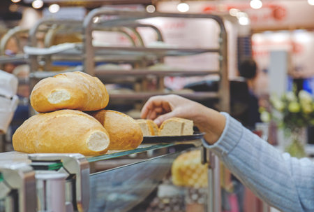 woman's hand takes a piece of bread to taste.の写真素材