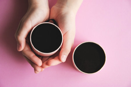 girl s hands hold a gift box over pink background, surprise for little princess.の写真素材