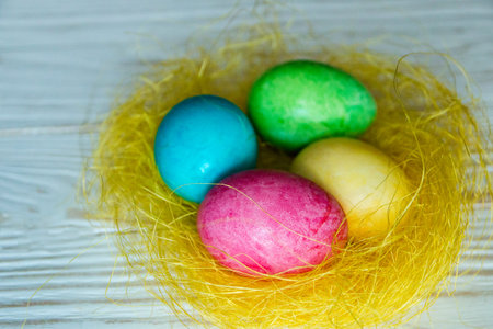 colorful Easter eggs on yellow decorative straw.