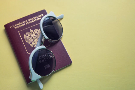 sunglasses a russian passport on a yellow background preparation for the journey.の写真素材