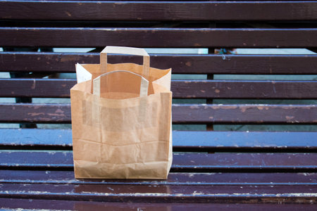 paper bag with a takeaway on the bench.の写真素材