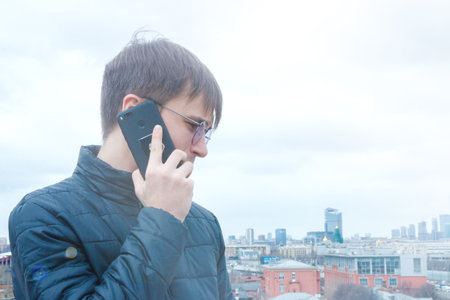 a young cute man talking on a mobile device.の写真素材