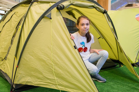 Young beautiful girl sitting in tourist tent.の写真素材