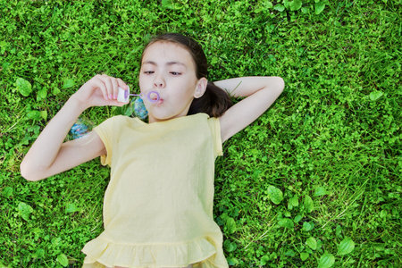 Cute little girl is blowing a soap bubbles.の写真素材