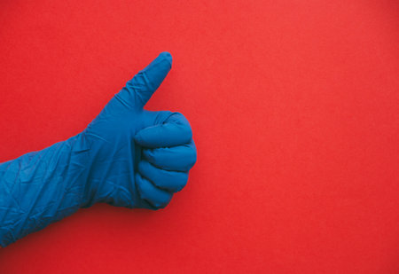 insulated hand in blue glove with positive sign and approval.の写真素材