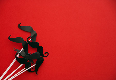 flatlay overhead top black paper photo booth props mustache red background copy space.の写真素材