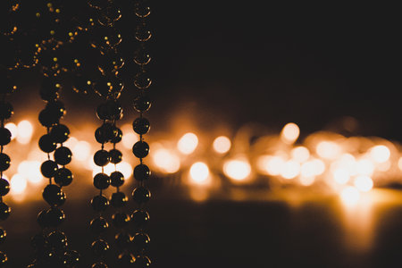 decorative beads on a background of glowing garland in a low key.の写真素材