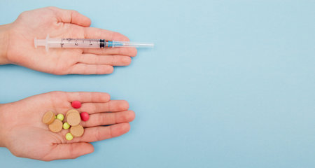 Female hands holding different medicines tablets and another had holding syringe, the choice of...
