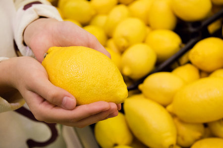 Vegetarians and fresh fruit and vegetables on the nature of the theme: human hand holding a lemon.の写真素材