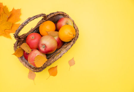 apple in basket on yellow background with autumn leaves. composition and concept of autumn.の写真素材