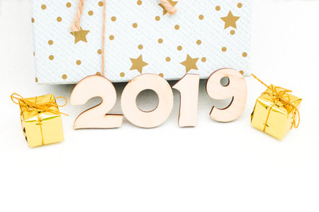 gold gift boxes and symbol numbers 2019 new year on white background, simple flatlay card of new yearの写真素材
