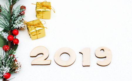 gold gift boxes, decorative spruce branch and symbol numbers 2019 New year on white background, simple flatley Christmas card. Selective focus.の写真素材
