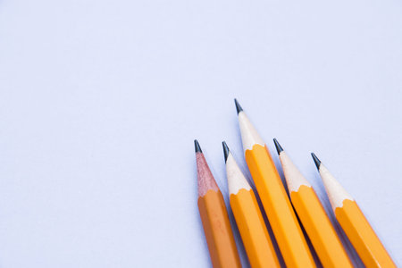 five simple pencils on a lilac background with a copy space.
