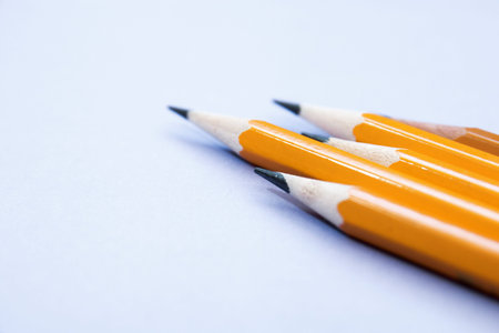 five simple pencils on a lilac background with a copy space.