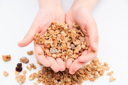 Crispy muesli dry Breakfast in hands isolated on white background selective focus, top view.の写真素材